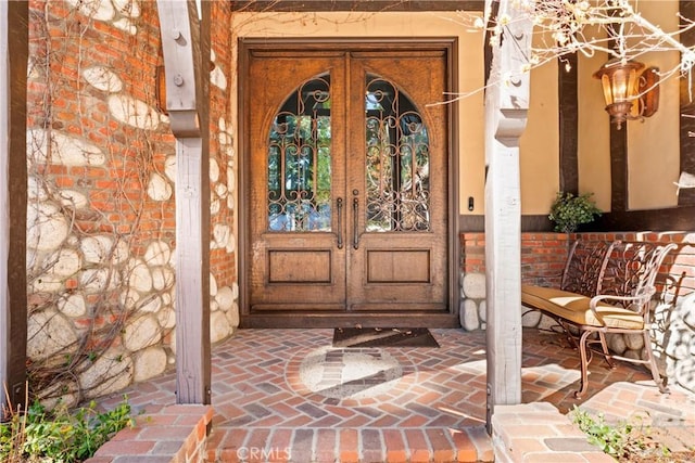 view of exterior entry with french doors and brick siding