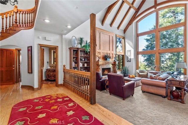 sitting room featuring hardwood / wood-style flooring, high vaulted ceiling, and a large fireplace