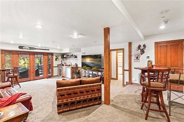 living room featuring light carpet, beverage cooler, a dry bar, and french doors