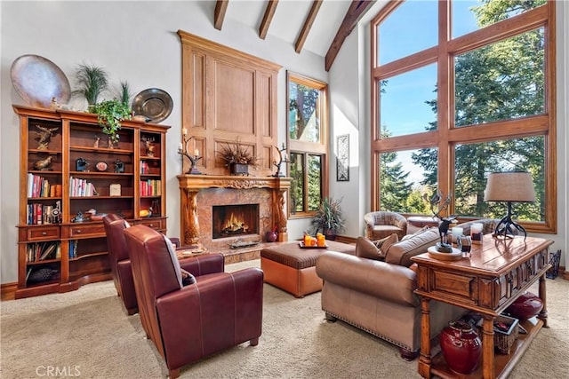 interior space featuring high vaulted ceiling, beamed ceiling, a fireplace, and light colored carpet