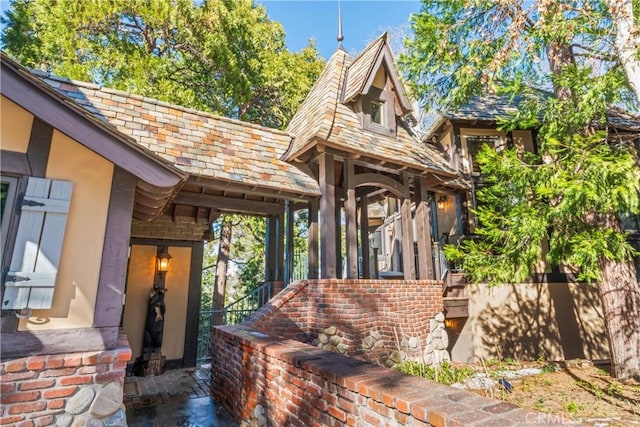 property entrance with brick siding and a high end roof