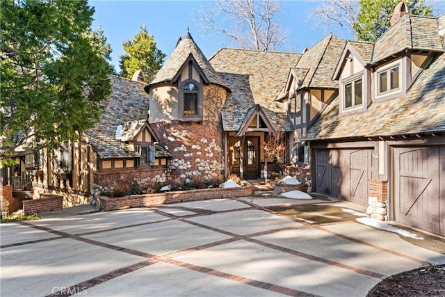 145 Pheasant Run, Lake Arrowhead, CA 92352 - tudor house with a high end roof, stucco siding, concrete driveway, a garage, and stone siding