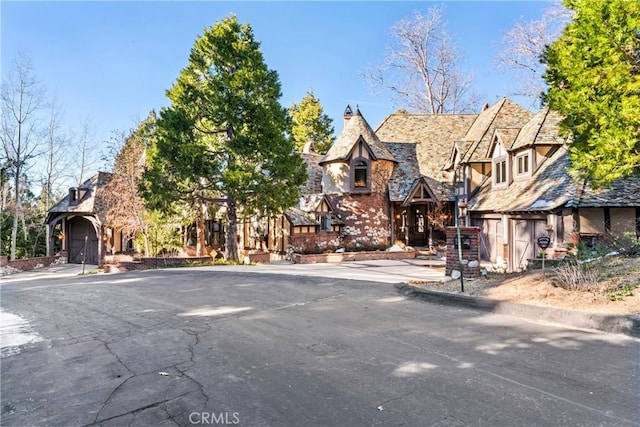 145 Pheasant Run, Lake Arrowhead, CA 92352 - tudor-style house with stone siding and a chimney