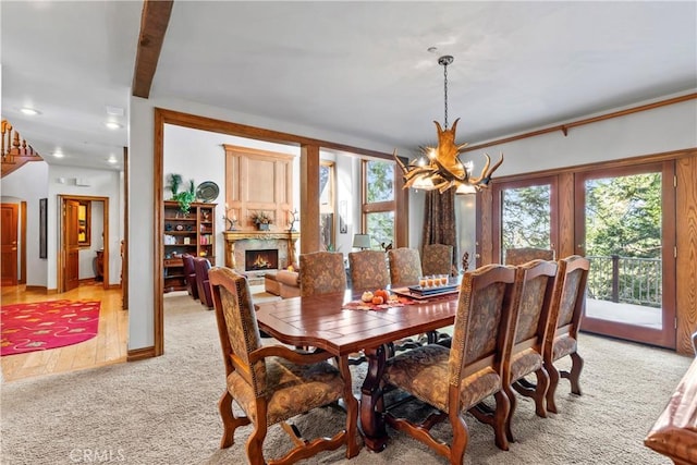 145 Pheasant Run, Lake Arrowhead, CA 92352 - dining space featuring a chandelier, plenty of natural light, light colored carpet, a high end fireplace, and recessed lighting
