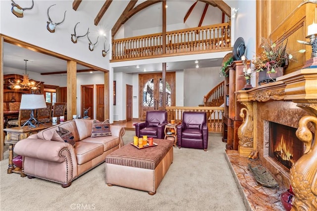 carpeted living area with a chandelier, high vaulted ceiling, a premium fireplace, stairway, and beamed ceiling