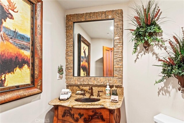 half bathroom with vanity and toilet