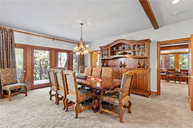 dining space featuring light carpet, beamed ceiling, a wealth of natural light, and a notable chandelier