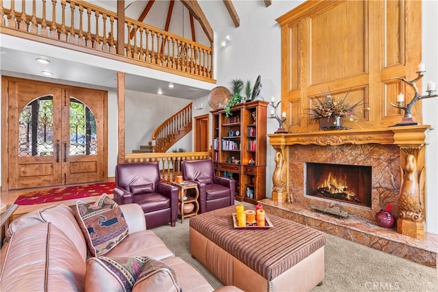 living room featuring carpet, french doors, a towering ceiling, and stairs