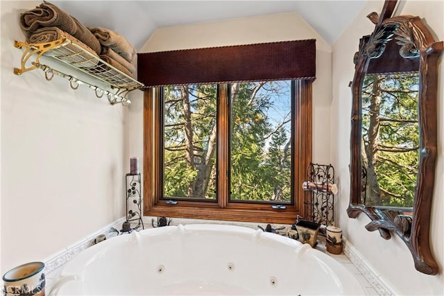 bathroom featuring lofted ceiling and a jetted tub