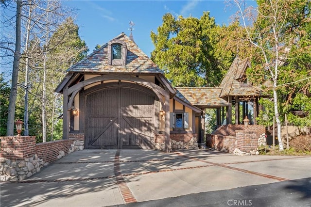 chalet / cabin with a high end roof, concrete driveway, and an attached garage