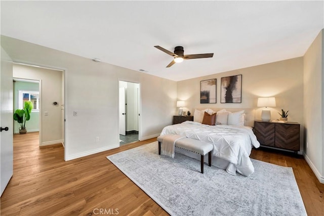 bedroom with visible vents, a ceiling fan, baseboards, and wood finished floors