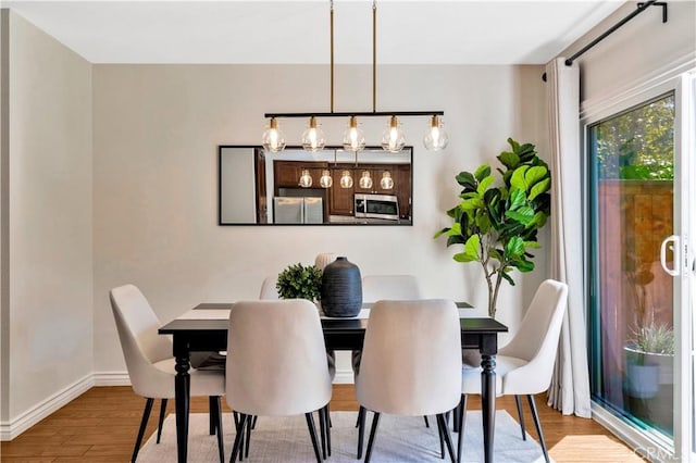 dining area featuring wood finished floors and baseboards