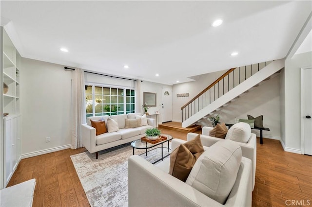 living area featuring stairway, recessed lighting, baseboards, and wood finished floors