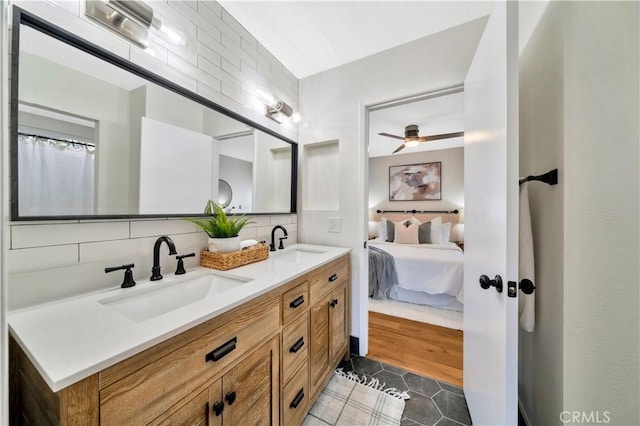 bathroom with tasteful backsplash, tile patterned floors, ensuite bath, and a sink