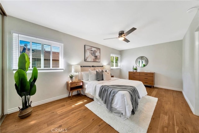 bedroom featuring a ceiling fan, baseboards, and wood finished floors