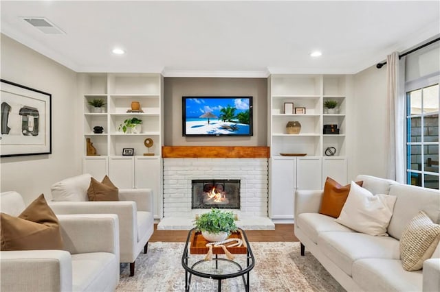 living room featuring a fireplace, crown molding, wood finished floors, and visible vents