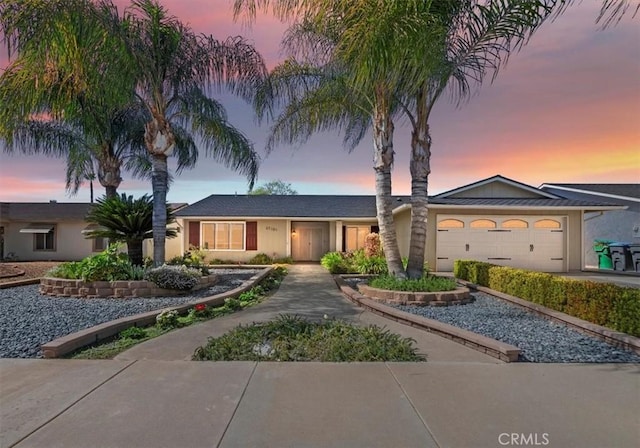 ranch-style house featuring a garage, driveway, and stucco siding