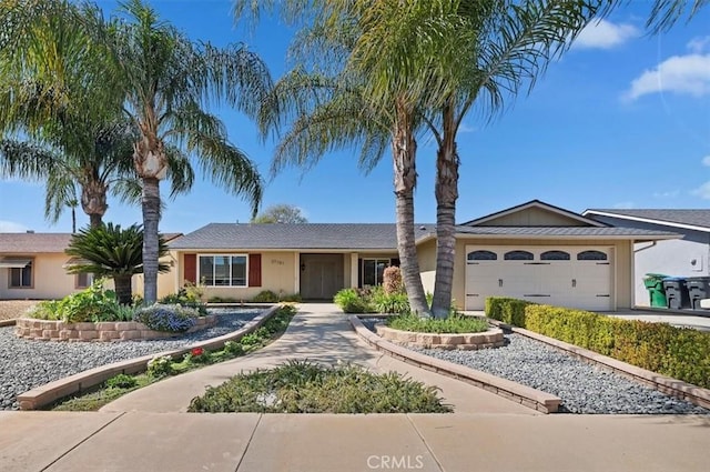 ranch-style house featuring a garage, driveway, and stucco siding