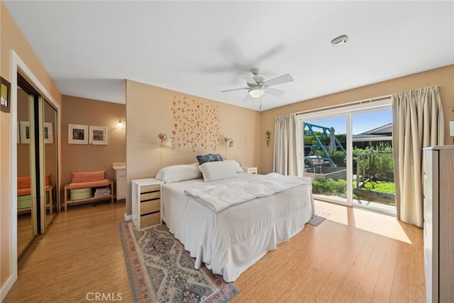 bedroom with access to exterior, light wood-style flooring, and a ceiling fan