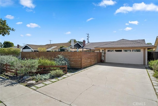 view of front of property featuring driveway, an attached garage, and fence