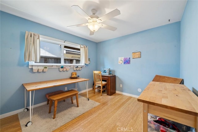 home office with ceiling fan, baseboards, and wood finished floors