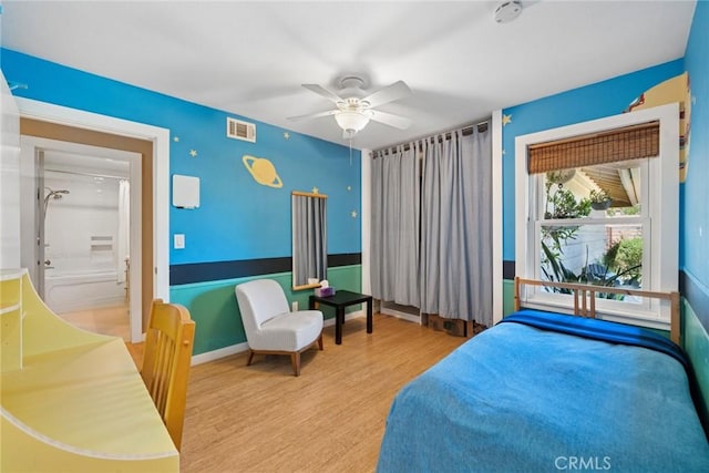 bedroom with baseboards, ceiling fan, visible vents, and wood finished floors