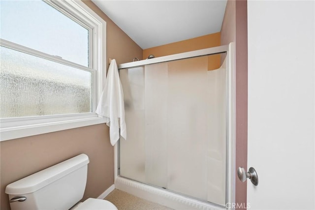 full bathroom featuring baseboards, a shower stall, and toilet