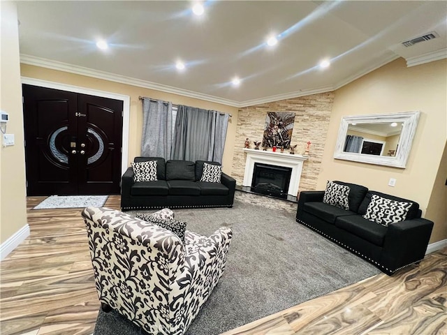 living room with baseboards, visible vents, vaulted ceiling, crown molding, and a fireplace