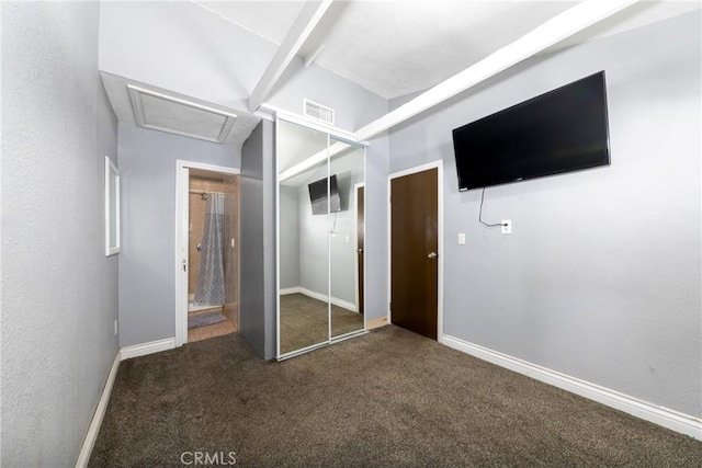 unfurnished bedroom featuring a closet, carpet flooring, attic access, and visible vents