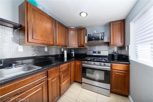 kitchen with gas range, dark countertops, and backsplash
