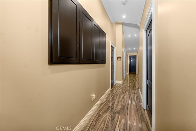 hallway featuring dark wood finished floors, recessed lighting, baseboards, and ornamental molding