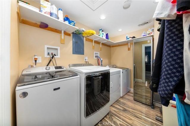 washroom featuring visible vents, electric panel, laundry area, light wood-style flooring, and independent washer and dryer