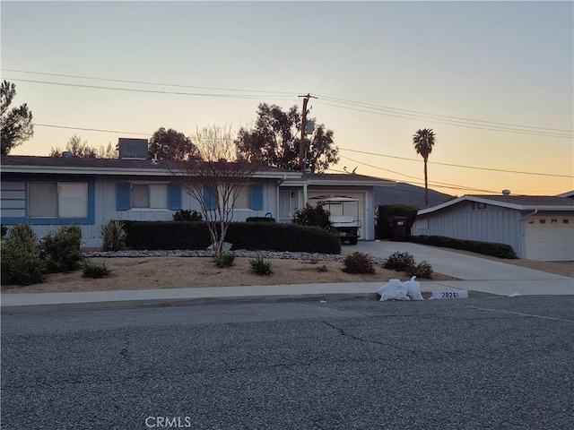 ranch-style house featuring concrete driveway and an attached garage