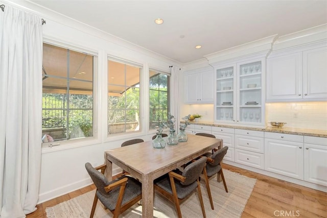 dining area featuring light wood-type flooring, a wealth of natural light, and baseboards