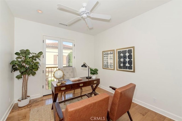 office space featuring light wood-style floors, baseboards, visible vents, and ceiling fan