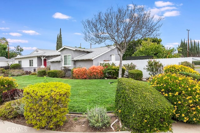 exterior space featuring a front yard, fence, and stucco siding