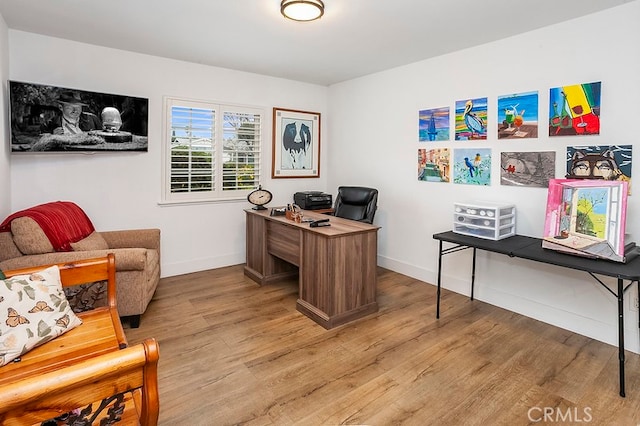 office featuring baseboards and light wood finished floors