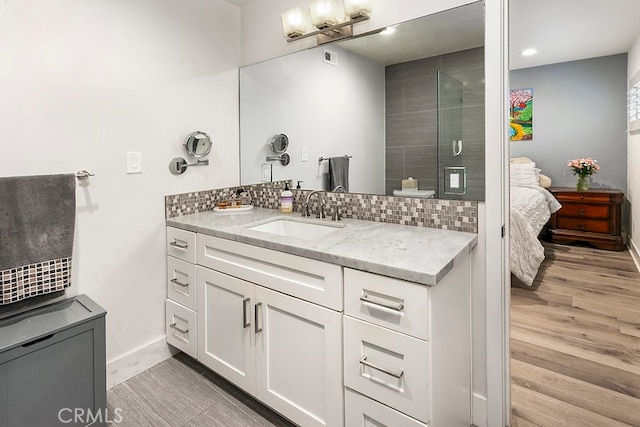 full bath with a stall shower, tasteful backsplash, connected bathroom, and wood finished floors