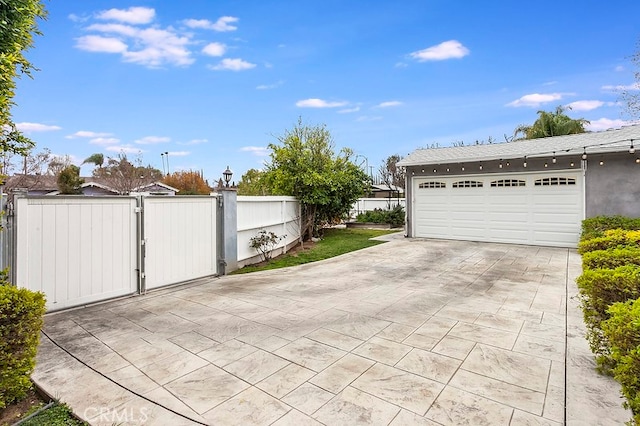 garage featuring fence and a gate