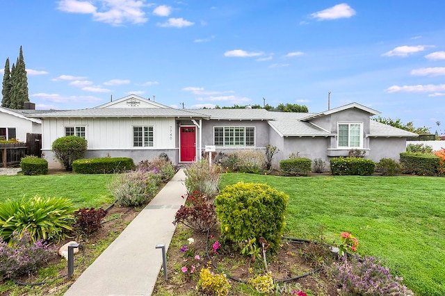 ranch-style house with fence and a front lawn