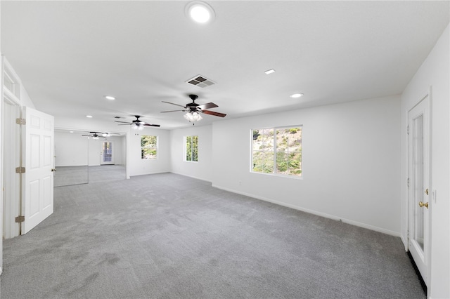 empty room with visible vents, carpet floors, a wealth of natural light, and recessed lighting