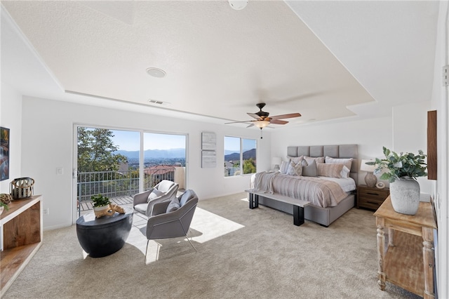 bedroom with carpet floors, visible vents, ceiling fan, a mountain view, and access to outside