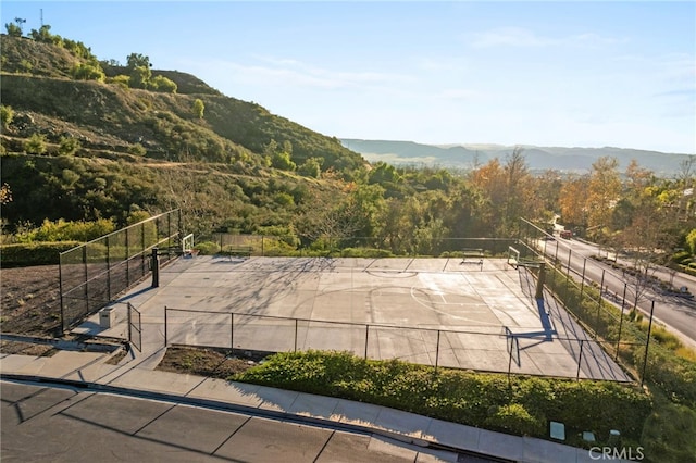 view of community with a mountain view and fence