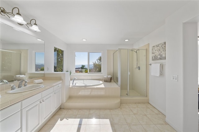 bathroom featuring a garden tub, a shower stall, and vanity