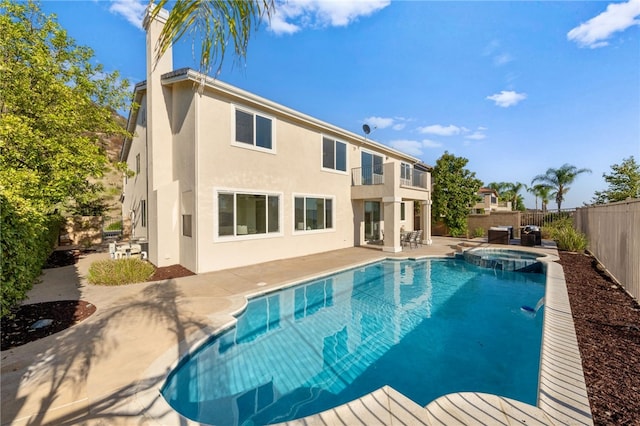 view of swimming pool featuring a pool with connected hot tub, a patio area, and a fenced backyard