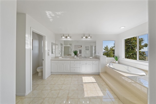 full bathroom with a garden tub, toilet, a sink, tile patterned floors, and double vanity