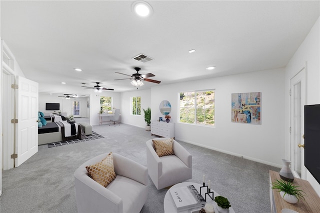 carpeted living area with visible vents, a wealth of natural light, and recessed lighting