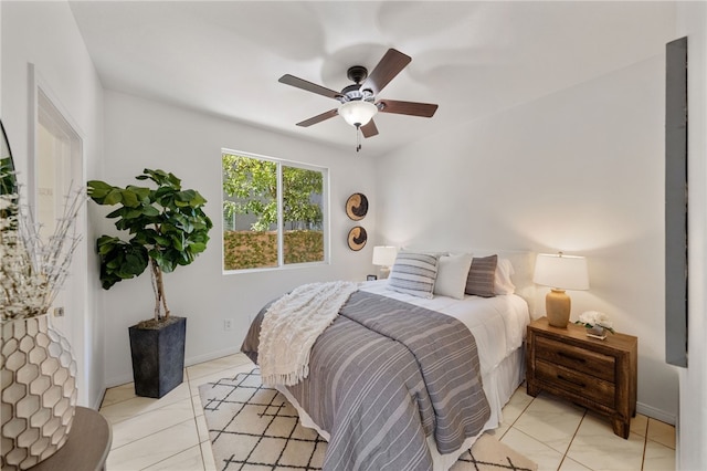 bedroom with light tile patterned floors, a ceiling fan, and baseboards