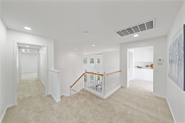 corridor with recessed lighting, carpet floors, visible vents, baseboards, and an upstairs landing