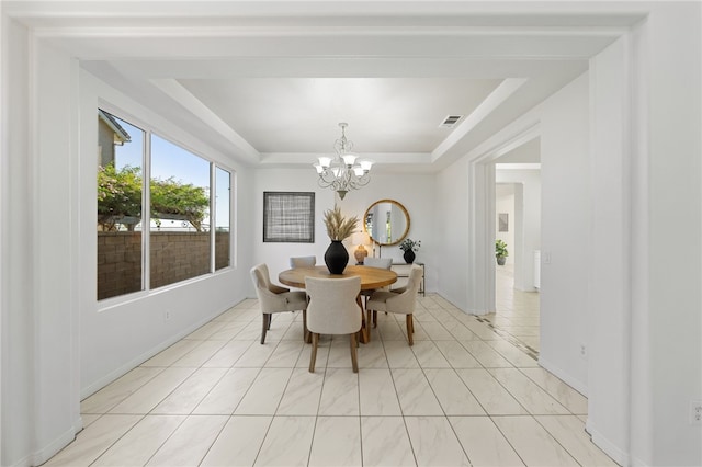 dining space featuring a chandelier, a tray ceiling, visible vents, and light tile patterned flooring